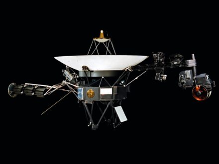 Sonda Voyager z dużą anteną paraboliczną, generatorami RTG na wysięgniku po lewej i instrumentami naukowymi na wysięgniku po prawej, ze Złotą Płytą na korpusie
