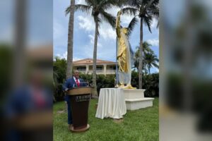Pozłacany pomnik Donalda Trumpa z uniesioną pięścią podczas ceremonii odsłonięcia w Trump National Doral na Florydzie.