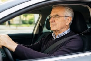 Senior za kierownicą samochodu w kontekście nowych przepisów UE o prawach jazdy